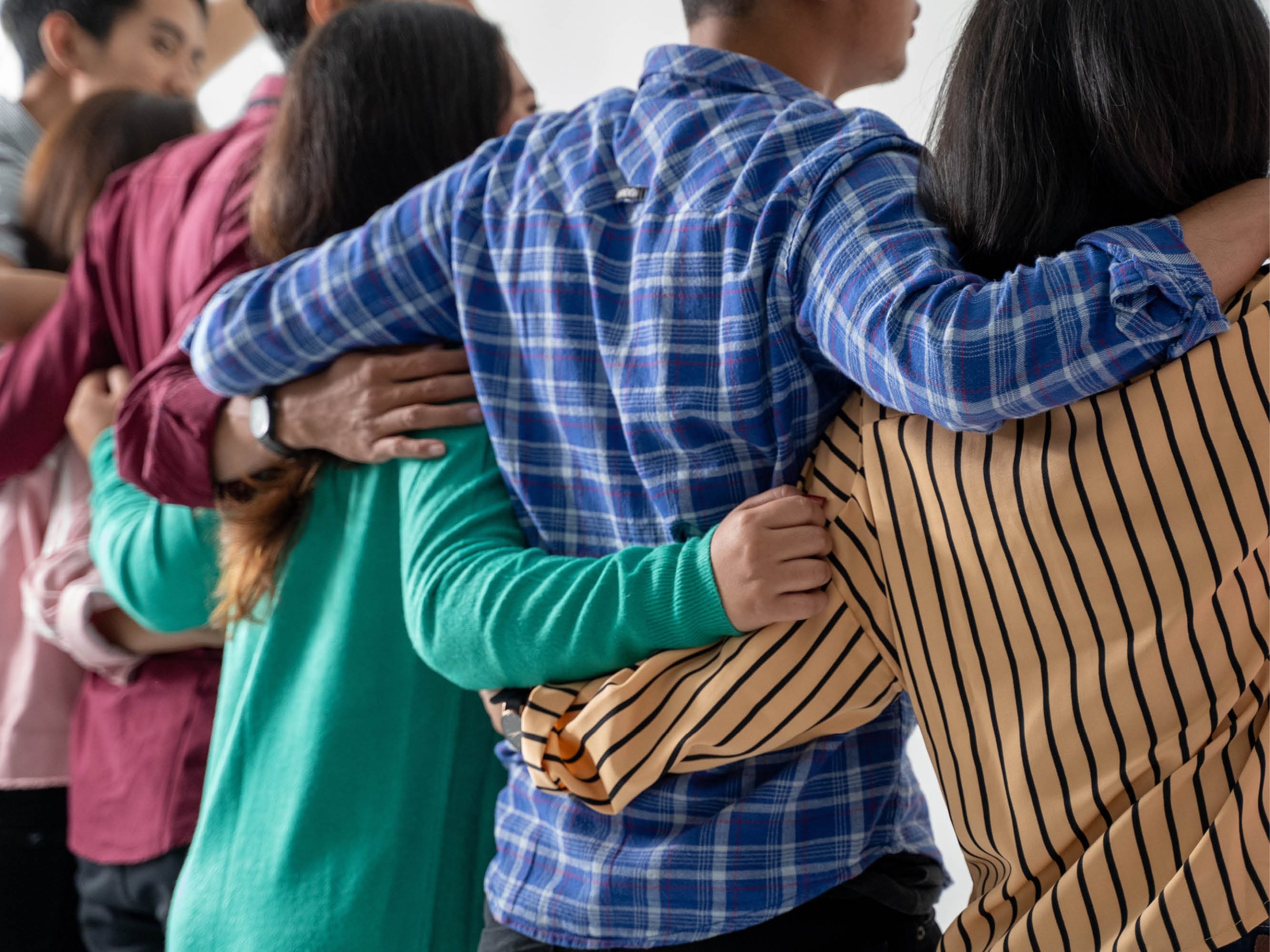 Unga personer står i rad och håller vänskapligt varandra om ryggen