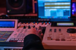 Närbild på en hand över ett mixerbord under en kurs i all lära sig skapa beats och musik.